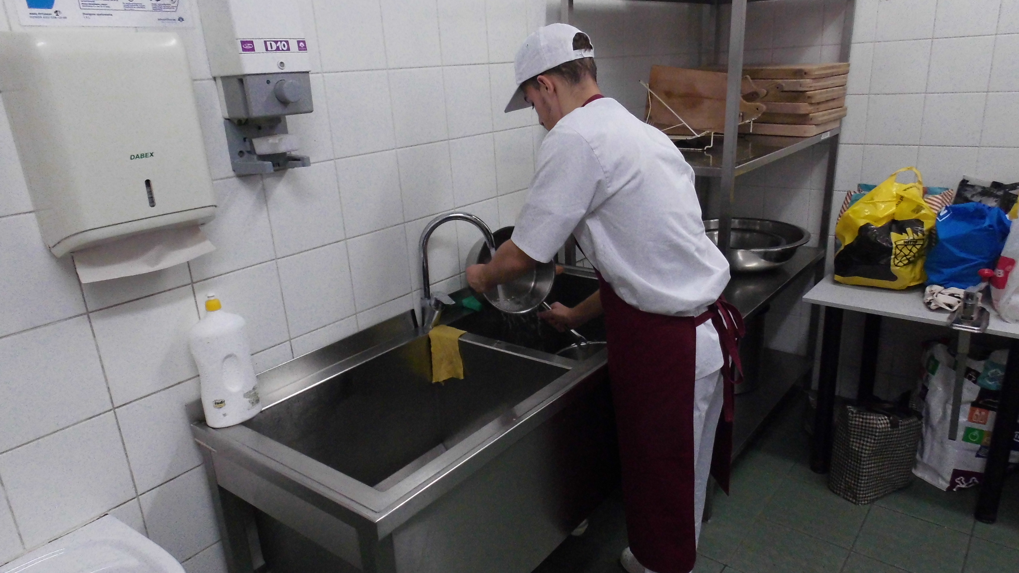 Uczeń realizujący praktyczną naukę zawodu w Zmywalni naczyń oraz sprzętu kuchennego