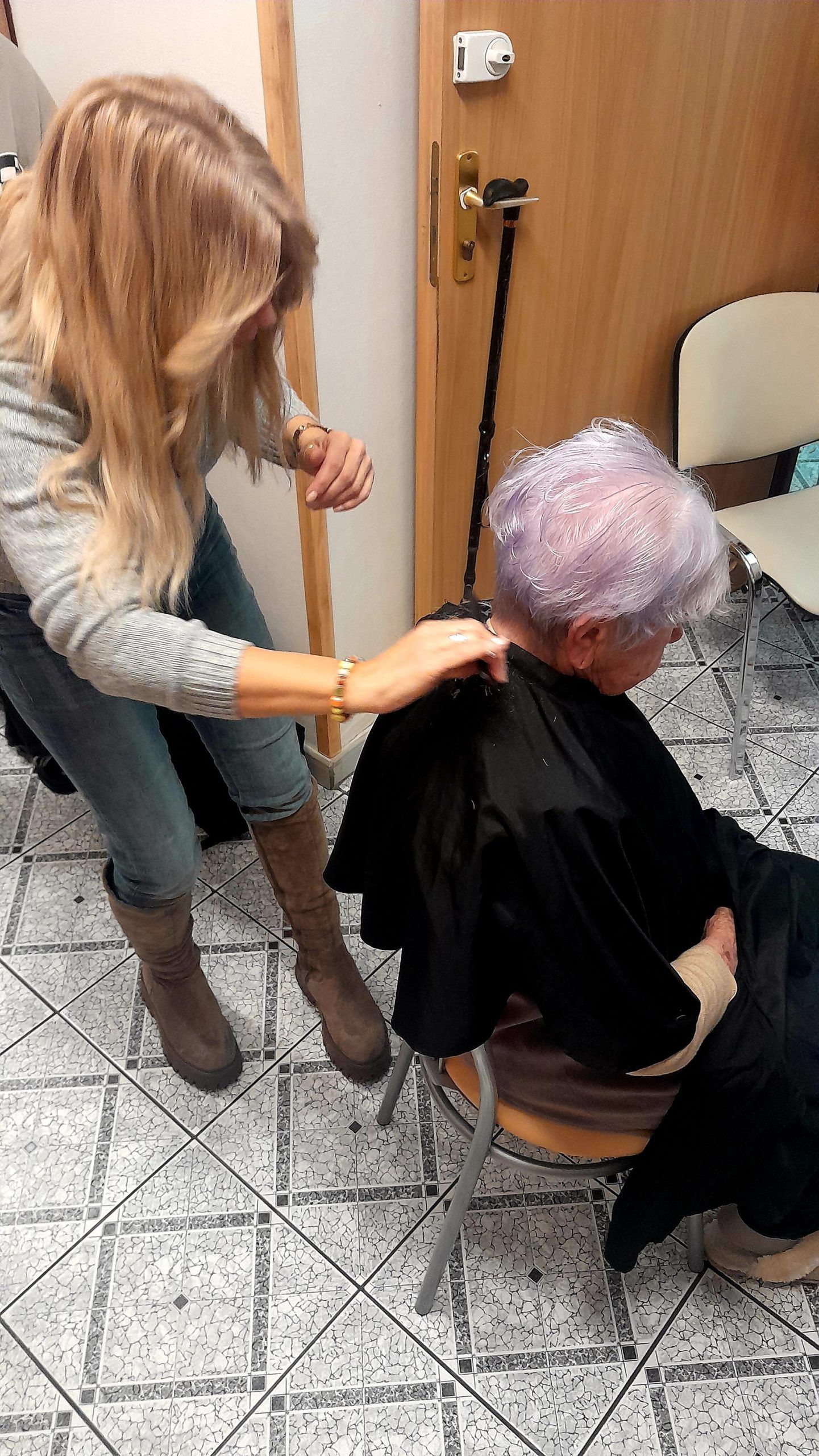 Wykonywanie zabiegów fryzjerskich na głowie starszej osoby